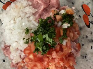 onions, tomatoes, cilantro, ground pork on counter, albondigas ingredients
